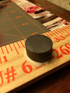 Glue a stack of two magnets on the yardstick with wood glue.